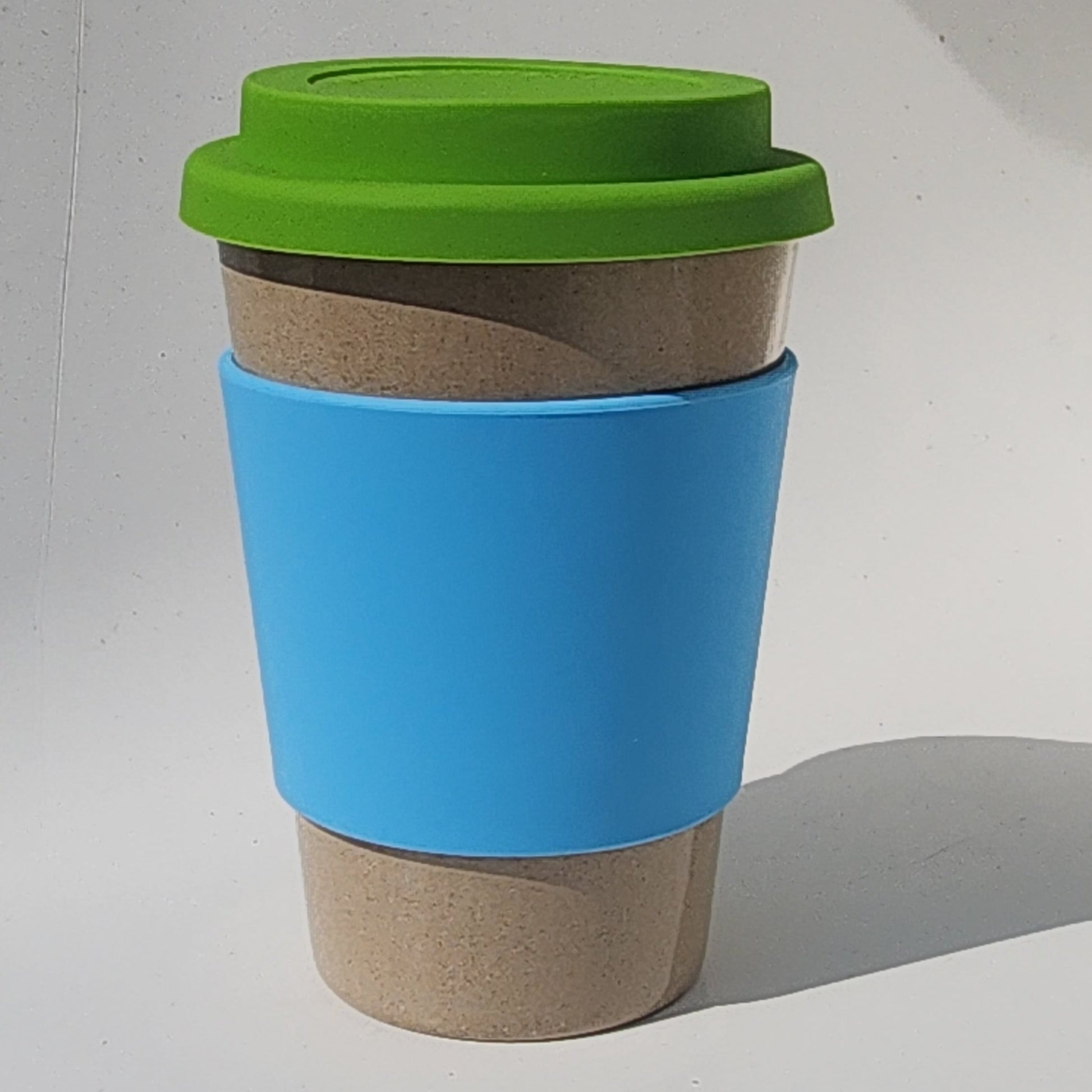 Cylindrical container with a blue lid and green base on a white surface