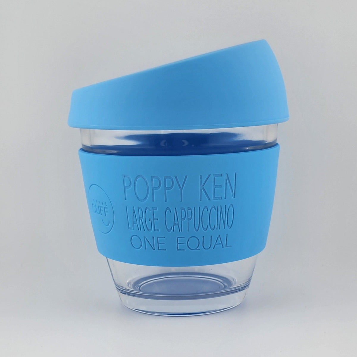 A reusable coffee cup with a bright blue silicone sleeve and matching blue lid, shown on a plain light gray background. The sleeve is printed with the brand name 'POPPY KEN' and the text 'LARGE CAPPUCCINO ONE EQUAL'.