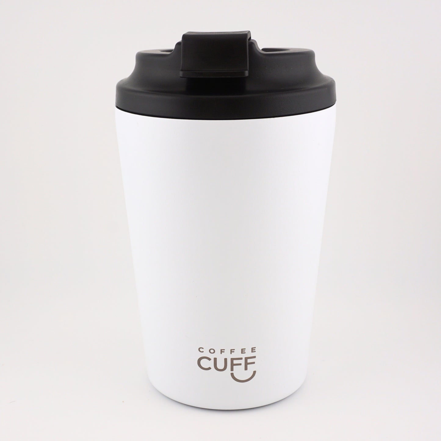 White coffee tumbler with black lid on a light gray background